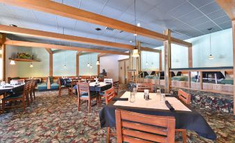 a dining room with several tables and chairs arranged for a group of people to enjoy a meal together at Best Western Prairie Inn  Conference Center