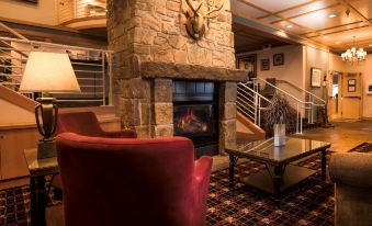 a cozy living room with a red couch , a fireplace , and a staircase leading to the second floor at The Landing Hotel