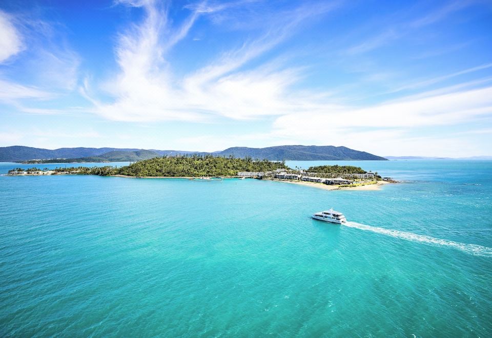 aerial view of a boat sailing on a body of water , with an island in the background at Daydream Island Resort