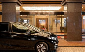 "a black car is parked in front of a hotel entrance with the name "" new york hotel ""." at Keio Plaza Hotel Hachioji