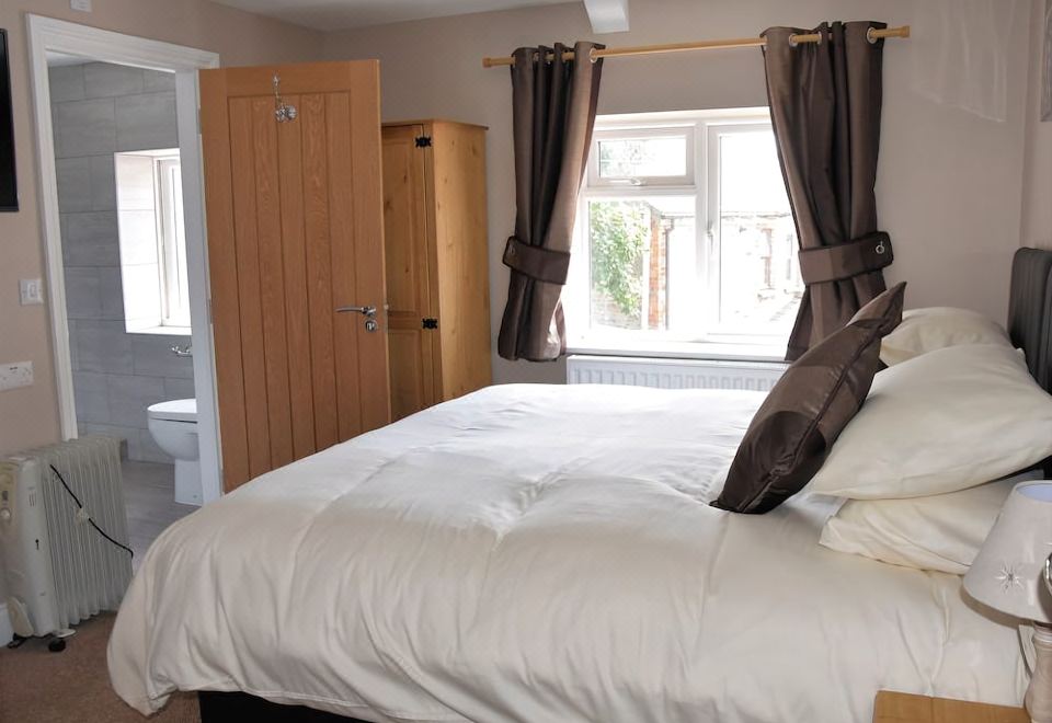 a clean and well - organized bedroom with a large bed , a closet , and a bathroom at The Red Lion