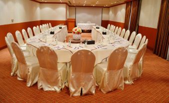 a large conference room with multiple chairs arranged in a semicircle around a long table at Golden Hotel