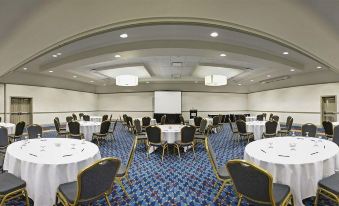 a large conference room with multiple tables and chairs arranged for a meeting or event at DoubleTree by Hilton Pittsburgh Monroeville Convention Center