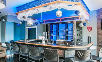 a bar with a blue and silver theme , featuring a variety of chairs and bottles at Hotel le Versailles