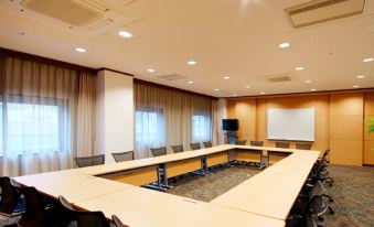 a large conference room with multiple chairs arranged in a semicircle around a long table at Daiwa Roynet Hotel Hachinohe