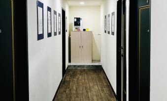 a long hallway with wooden floors and white walls , featuring black doors on both sides at Leisure