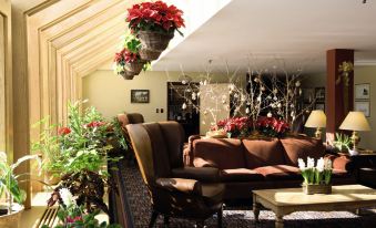 a cozy living room with a couch , chair , and potted plants hanging from the ceiling at Trapp Family Lodge