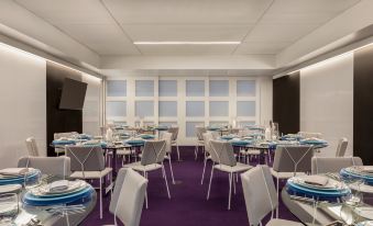 a large conference room with multiple rows of chairs arranged in a semicircle around a table at Yotel Boston