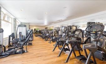 a large , well - equipped gym with a variety of exercise equipment , including treadmills , weight machines , and other cardio machines at Hotel Heimatlodge