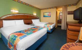 a hotel room with two beds , one of which has a colorful bedspread , and a colorful wall hanging at Disney's All-Star Movies Resort