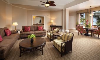 The living room is decorated in a western style and features couches, chairs, and tables in the center at The Royal Hawaiian, A Luxury Collection Resort, Waikiki