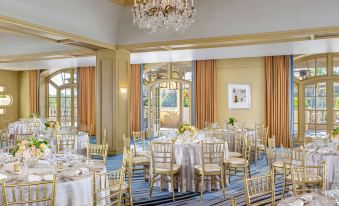 a luxurious dining room with gold and blue accents , chandeliers , tables set for a formal dinner at The Ritz-Carlton, Laguna Niguel