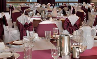 a large dining room with numerous tables and chairs arranged for a formal event , possibly a wedding reception at Red Lion Hotel Port Angeles Harbor