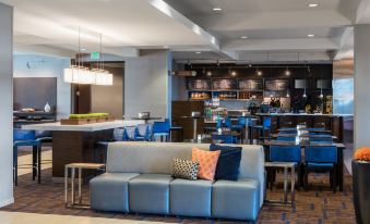 a modern lounge area with a couch , bar stools , and an interior view of the lobby at Courtyard Seattle Federal Way
