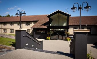 "a large building with a black and white exterior , featuring a sign that reads "" b & b "" above the entrance" at Gloucester Robinswood Hotel, BW Signature Collection