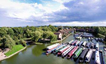 aerial view of a river with numerous boats docked , surrounded by houses and trees , under a cloudy sky at Peartree Lodge Waterside