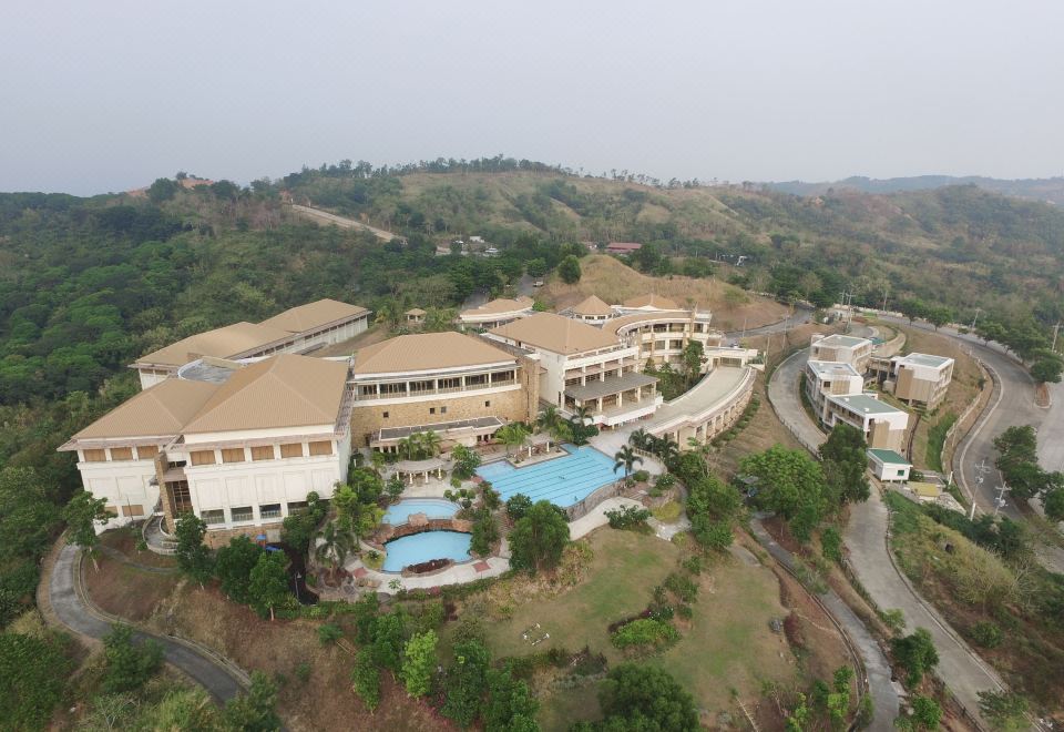 aerial view of a large resort with multiple buildings and a swimming pool surrounded by trees and mountains at Timberland Highlands Resort
