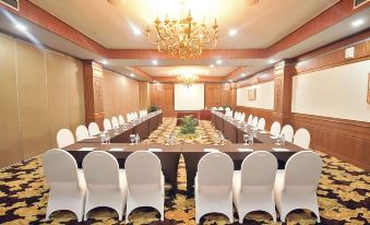 a large conference room with multiple rows of chairs arranged in a semicircle around a long table at Planet Holiday Hotel & Residence