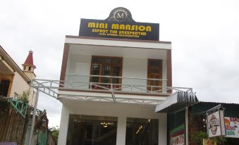 "a small building with a sign that reads "" mini mansion "" prominently displayed on the front of the building" at Mini Mansion