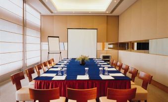A spacious conference room is arranged with long tables and chairs for business meetings or private events at Winland 800 Hotel