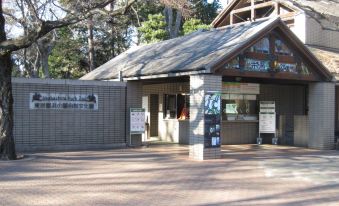 a building with a sign on the front , surrounded by trees and located in a park at Kichijoji Tokyu Rei Hotel