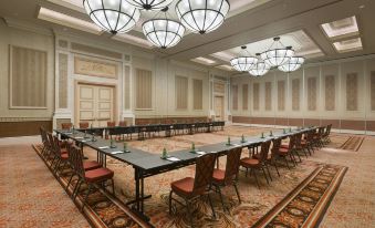There is an empty large meeting room with rows of tables and chairs along the far end at Sheraton Grand Macao