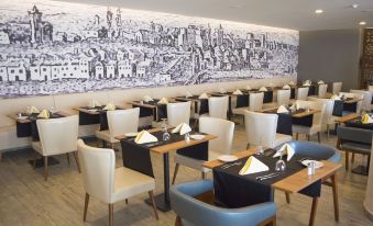 a restaurant with white chairs and tables , a black tablecloth , and a large wall mural of a cityscape at AP Maria Nova Lounge