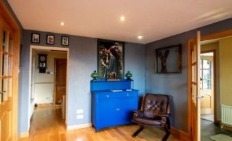 a blue cabinet is sitting on a wooden floor in a room with hardwood floors at Burnside Cottage