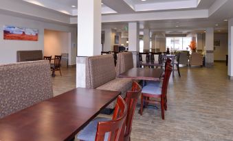 a large dining room with wooden tables and chairs , as well as a kitchen area at Holiday Inn Express & Suites Williams