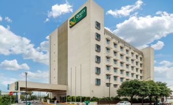 "a large , white hotel building with a green sign that reads "" south place suites "" on it" at Quality Inn Monterrey la Fe