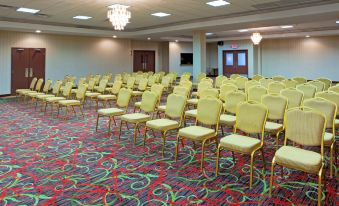 a large conference room with rows of chairs arranged in a semicircle , ready for an event at Wyndham Garden Dover