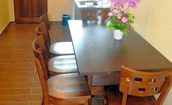 a wooden dining table with four chairs and a vase of flowers in the center at Refarm