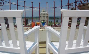 a rooftop deck with white chairs and railings , overlooking a body of water and a city skyline at Peabody Memphis