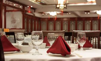 a dining table set for a formal meal , with wine glasses and napkins on the table at Red Lion Inn and Suites Victoria