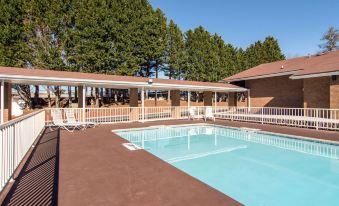 an outdoor swimming pool surrounded by a building , with several people enjoying their time in the pool at Quality Inn