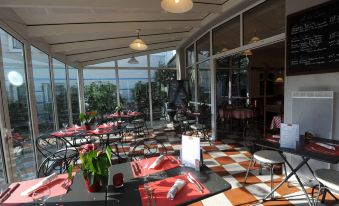 an outdoor dining area at a restaurant , with tables and chairs arranged for guests to enjoy their meal at Ibis Nantes Saint-Herblain