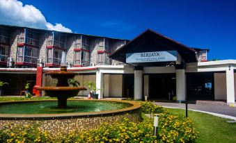 a large building with a fountain in front of it and flowers in front of it at Berjaya Beau Vallon Bay Resort & Casino