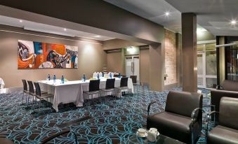 a large , well - lit conference room with multiple tables and chairs arranged for a meeting or event at Aurora Ozone Hotel Kangaroo Island