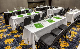 a conference room set up for a meeting , with multiple tables and chairs arranged in rows at Holiday Inn Richmond