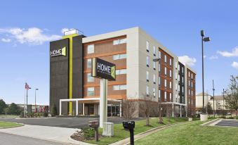 "a large hotel building with a sign that says "" home "" and has a sign for the "" home "" and a box outside" at Home2 Suites by Hilton Oxford