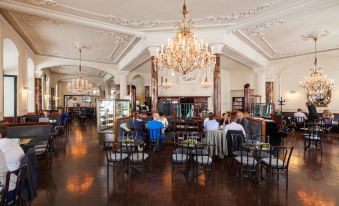 a large , ornate dining room with multiple tables and chairs , creating a cozy atmosphere for diners at Hotel Central