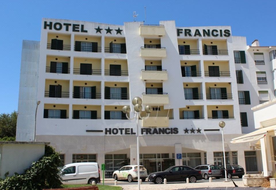 "a large hotel with the name "" hotel francis "" written on it , surrounded by cars parked in front of it" at Hotel Francis