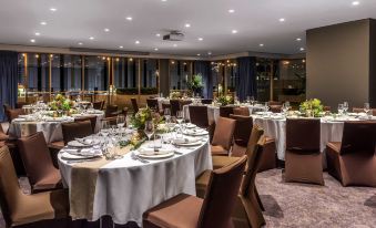 a well - decorated dining room with several round tables and chairs arranged for a formal event at Novotel Sydney Darling Harbour