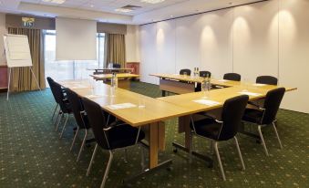 a conference room with several chairs arranged in a semicircle around a long table , providing seating for a group of people at Holiday Inn Glasgow - East Kilbride