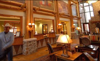 a hotel lobby with a check - in desk and a staircase leading to the second floor at Quartz Mountain Resort
