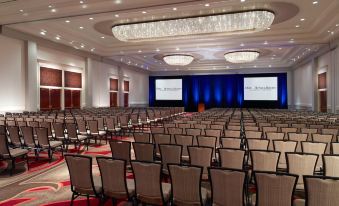 a large conference room with rows of chairs arranged in a semicircle , ready for an event at Omni Providence