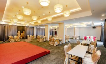 a large , well - lit room with multiple tables and chairs arranged for a meeting or event at Livingston Hotel