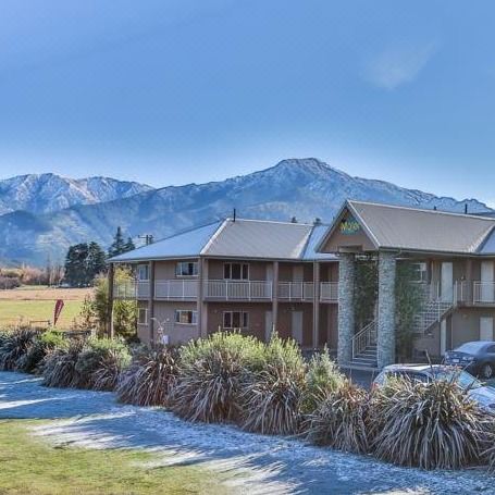 a house with a car parked in front of it and mountains in the background at Hanmer Springs Retreat