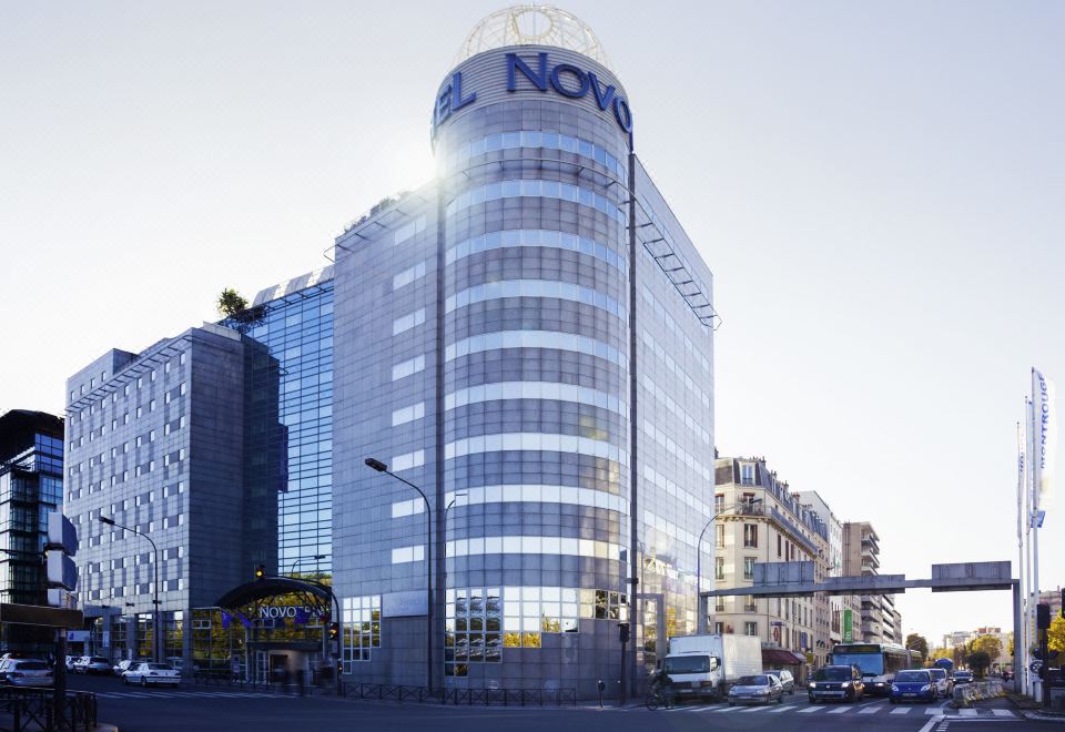 "a large white building with the word "" novo "" on it , situated in a city street" at Novotel Paris 14 Porte d'Orleans