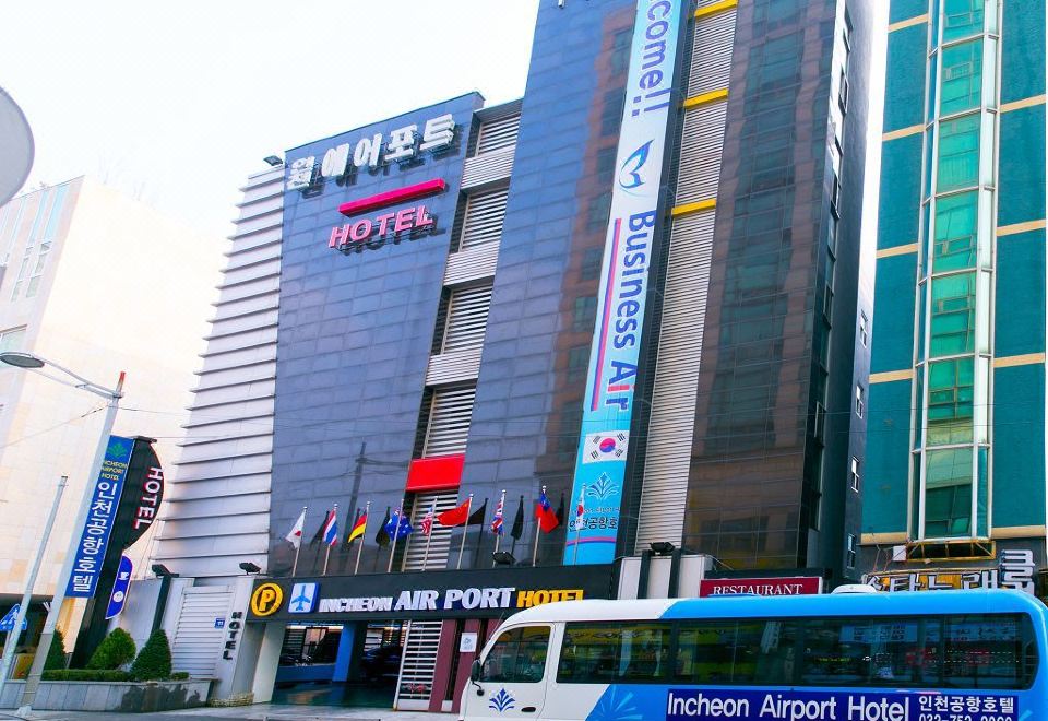"a large building with a sign that says "" incheon airport hotel "" and a bus parked in front of it" at Incheon Airport Hotel